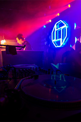 DJ Equipment In The Foreground And Chase LED Logo In The Background