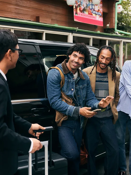 Three men casually conversing while getting out of a van