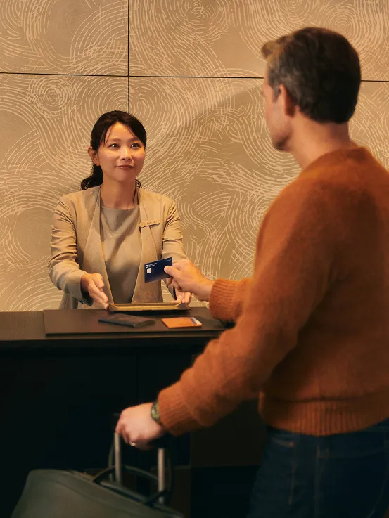 Man at the hotel counter checking in using his Chase Sapphire card