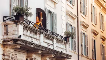 Woman standing at the balcony of J.K Place Roma